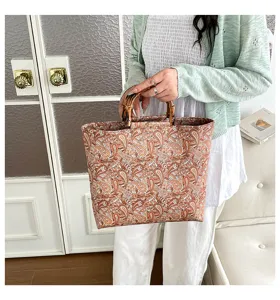 Vue détaillée du sac élégant avec un motif cachemire classique et des poignées en bambou uniques.