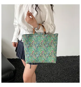 Vue détaillée d'un sac cabas rétro avec imprimé coloré et poignées élégantes en bambou.