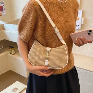 Stylish woven straw shoulder bag with elegant leather trim and chic hobo design for women.