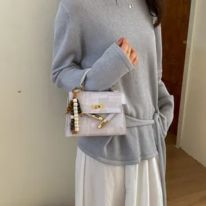 Femme mode élégant sac à main bandoulière avec fermeture à verrou et pendentif chic.