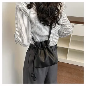 Sac seau minimaliste noir à cordon en cuir, sac bandoulière élégant pour femmes au quotidien.