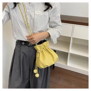 Détail du sac seau à cordon jaune, design souple en cuir sac bandoulière élégant.