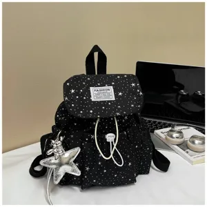 Detailansicht des schwarzen Mini-Rucksacks mit weißem Sternenmuster und silbernem Anhänger.