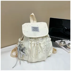 Milchweißer Mini-Sternen-Rucksack Detail mit Kordelzugverschluss und süßem silbernen Sternanhänger.