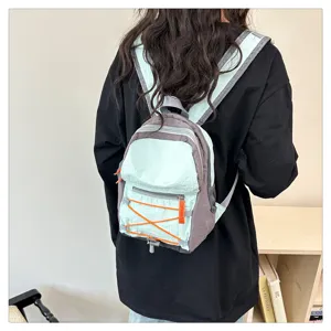 Mini canvas backpack detail view featuring trendy color block design and front bungee cord.