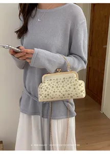 Vue détaillée d'un magnifique sac clutch vintage en strass avec chaîne dorée.