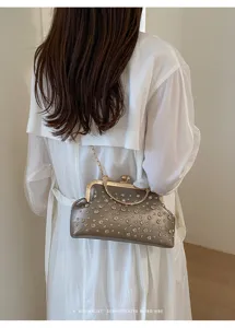 Vue détaillée de la pochette de soirée métallique tendance dotée de strass étincelants.