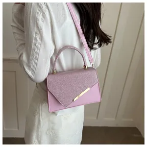 Pink glitter handbag detail, stylish evening shoulder bag with metal accent and top handle.