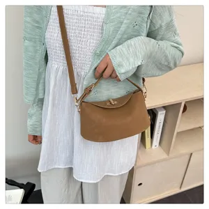 Élégant petit sac à main en cuir marron avec poignée et bandoulière pour femme au quotidien.