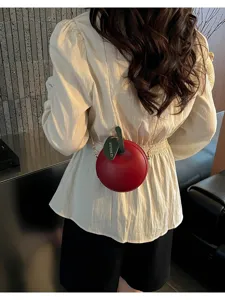 Mini red apple crossbody bag with gold chain strap and green leaf detail for stylish daily wear.