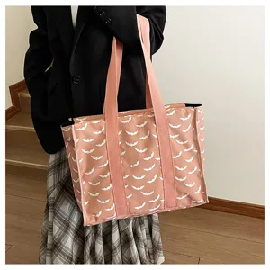 Vista detallada del bolso tote grande rosa con estampado de murciélagos y asas dobles.