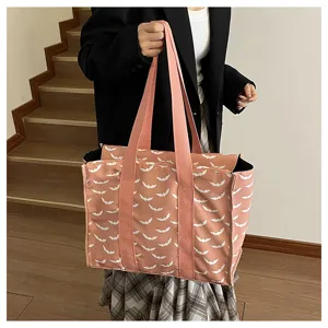 Vista detallada del bolso tote de lona rosa con patron de murcielago para deporte y viajes.