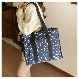 Vista detallada de un bolso shopper azul marino con motivo de murciélago para viajes.