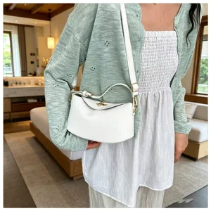 Détail de sac à bandoulière minimaliste en cuir blanc, design de fermoir élégant.