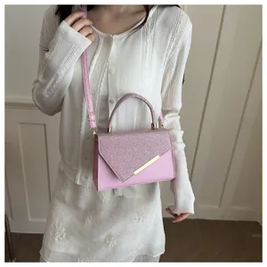 Close-up detail of the stylish pink sequin flap crossbody handbag with elegant metal bar accent.