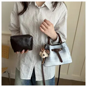 Casual women's bucket bag and pouch set with blue plaid pattern and brown leather straps.