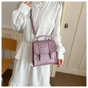 Dettaglio della borsa a tracolla a pois viola, elegante borsa alla moda con fibbia chic.