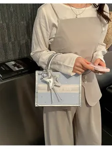 Stylish light blue mini tote bag with metallic silver trim, star pendant and double handles for women.