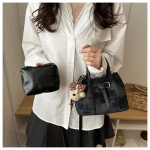 Detailed view of fashionable women bucket bag with small pouch and cute bear pendant charm.