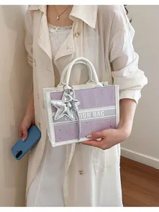 Detailed view of a fashionable purple starry tote bag with white handles and charm for women.