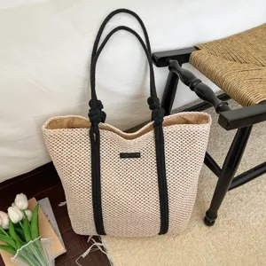 Detailopname van de geweven papieren touw tas met zwarte handvatten in een gezellige kamer.