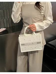 Stylish white star patterned tote bag with top handles, compact and chic design for women.