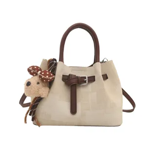 Stylish women's bucket bag with top handle, chic belt buckle and cute plush bear charm.