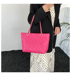 Primo piano della borsa tote trapuntata rosa, che mostra la texture e la tracolla in catena.