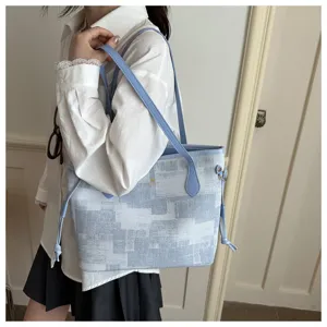 Detailaufnahme der modischen blau-weißen Mustertasche als Umhängetasche mit Lederriemen.