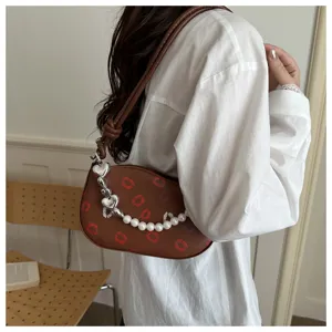 Sac à bandoulière croissant marron chic pour femme avec imprimé lèvres et chaîne perle.