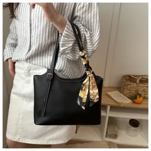 Vista dettagliata della elegante borsa a spalla in pelle nera da donna con foulard.