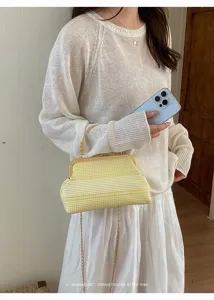Sac à main rayé chic avec poignée en métal et bandoulière chaîne, accessoire stylé.