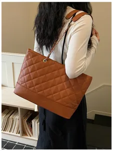 Detailansicht der braunen gesteppten Handtasche mit Kette, elegante Textur für den Alltag.