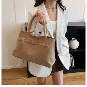 Detailed shot of a stylish khaki suede tote bag featuring an elegant belt and buckle design.