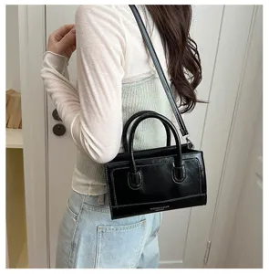Black PU leather handbag and crossbody bag with double top handles and sleek minimalist design.
