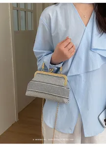 Sac à bandoulière chic rayé noir et blanc avec chaîne dorée pour un style quotidien.