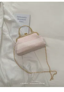 Vue détaillée d'un sac à main rétro à carreaux rose et blanc avec bandoulière dorée.