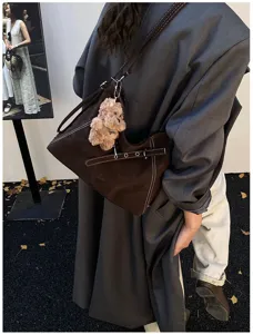 Retro braune Beuteltasche Detailansicht mit Kontrastnähten und süßem Plüsch-Bär-Anhänger.