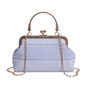 Blue and white checkered kiss lock cross body bag with metal handle and chain strap for women.