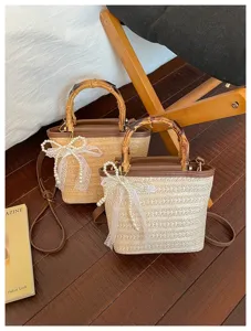 Close-up detail van zomer stro emmer tas met bamboe handvat en parel strik decoratie.