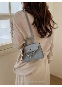 Joli sac Kelly bleu clair avec breloque en bois, sac bandoulière élégant pour femme tendance.