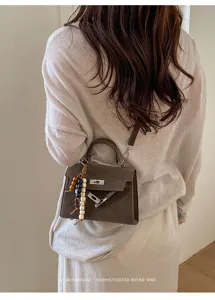 Minimalist retro brown top-handle shoulder bag detail view showing elegant style.