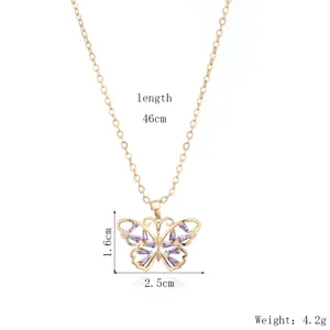 Détail de collier plaqué or avec élégant pendentif papillon ajouré et pierres violettes.