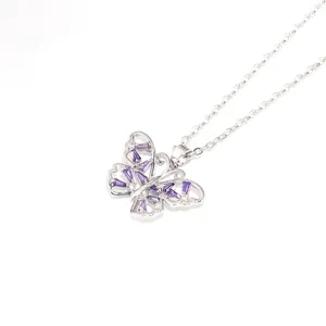 Collier papillon argenté gros plan, orné de zircones cubiques violettes et blanches.