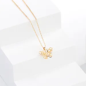 Vue rapprochée du collier pendentif papillon creux ton or avec des pierres de zircon étincelantes.