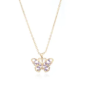 Gros plan détaillé d'un collier pendentif papillon doré orné de pierres violettes.