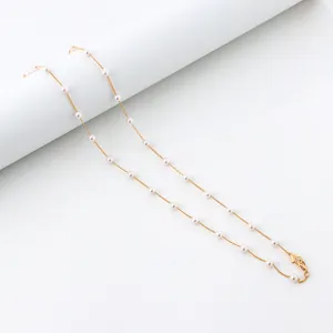 Detalle de cadena de perlas doradas con eslabones delicados para mascarilla u gafas.