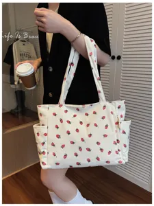 Kord-Shopper Detail mit niedlichem rotem Erdbeerprint und praktischer Seitentasche.