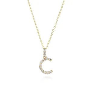 Close-up detail of the sparkling gold paved letter C pendant necklace, delicate and shiny link.