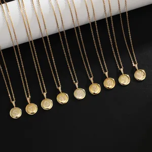 Gold stainless steel letter pendant necklace detail showcasing paved crystal alphabet charms.